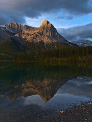 View of majestic mountain Ha Ling Peak in the Rocky Mountains near Canmore, Kananaskis Country, Alberta, Canada after sunrise reflected in water.