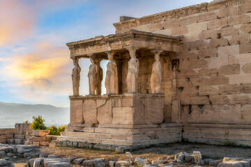 Erechtheion Temple (or Erechtheum) with the figures of Caryatids at the archaeological site of Acropolis in Athens, Greece at sunset. It was dedicated to both Athena and Poseidon. Golden soft light