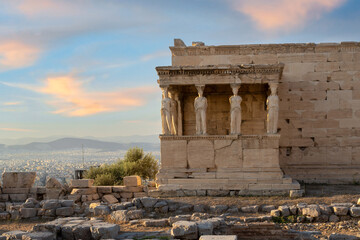The Caryatids of Erechtheion Temple (Erechtheum) at the archaeological site of Acropolis in Athens, Greece. Side view of the temple at late afternoon. Colorful clouds, blue sky, soft golden light