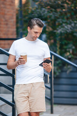 Fototapeta na wymiar Young man drinking coffee in the city outdoors