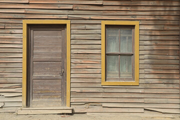 Fototapeta na wymiar puerta y ventana amarilla vieja cabaña de madera poblado del oeste 4M0A6518-as21