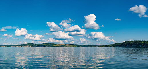 Panorama of a calm lake, the Kama River Russia Perm Krai, blue sky with clouds reflected in the...