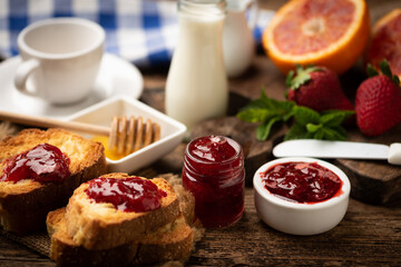 Strawberries with jam and glass of milk. Natural breakfast, rustic wooden