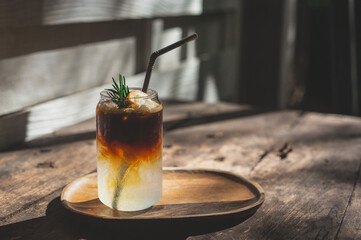 Iced coffee with lemon and mix soda on wood rustic. A glass of americano mixed with craft soda and...