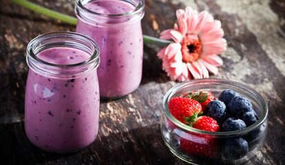 strawberry blueberry shake in sunlight on wood