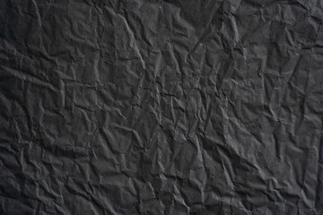 an empty wrinkled dark black tissue paper textured background
