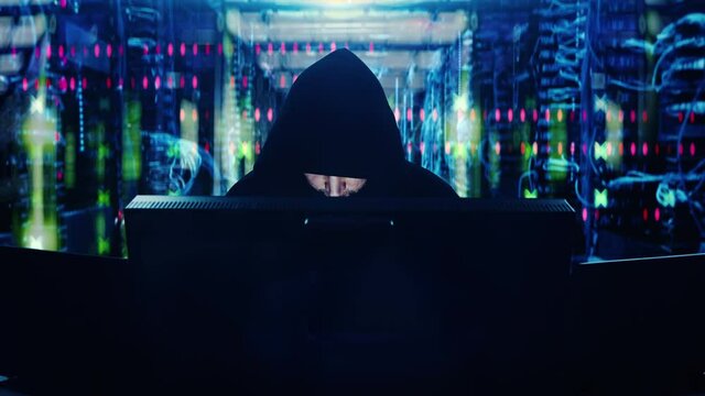 Male hacker typing on keyboard in server room, hacking into system, breach. Overly stylized comical portrayal of hackers