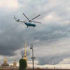 Passenger helicopter Mi-8 flies in the sky above the cathedrals of the city of St. Petersburg,...