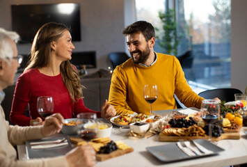 Happy family having dinner with red wine at home