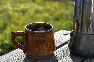 Ceramic cup with coffee outside in the garden prepared in a geyser coffee maker.