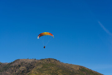 Paragliding Pilot Flying a Paraglider - 468448417
