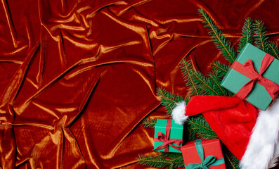 Christmas gift boxes and spruce branch on Crimson Red fabric background
