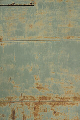 Beautiful abstract texture background. Rusty metal truck door fragment. Blue, white and brown. Creative backdrop design. Old worn iron panel with peeled off paint and scratches. Close up, copy space