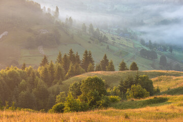 Green rolling hills over the alpine village