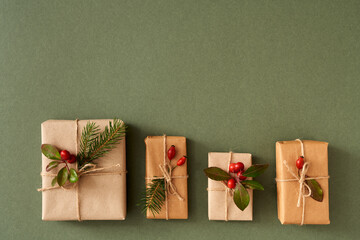 Christmas presents wrapped in ecological recycled paper - zero waste concept on green background
