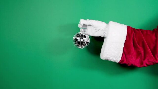 Christmas mock-up of a trend disko ball in Santa's hand, Christmas concept, brand.