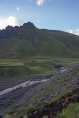 summer mountain landscape with blue sky and mountain river. beautiful sun rays are reflected on the mountain slope.