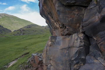 a large beautiful rock of different rocks stands at the top of the slope. Mountain landscape