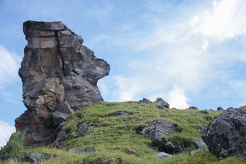 a large beautiful rock of different rocks stands at the top of the slope. Mountain landscape