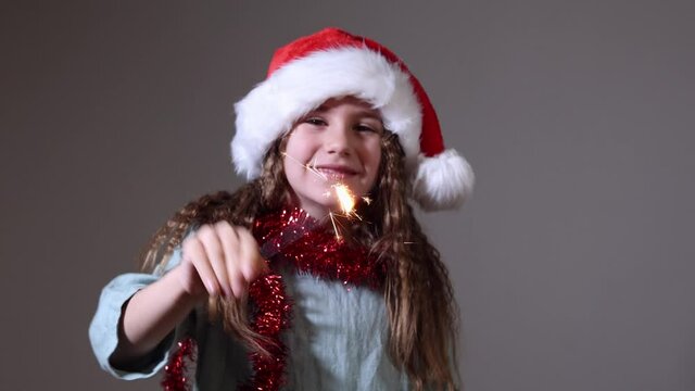 holidays, childhood and people concept - happy little girl with sparkler at home. Christmas. Slow Motion. Positive Emotions of People.