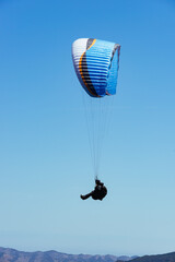 Paragliding Pilot Flying a Paraglider - 468452452