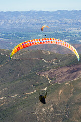 Paragliding Pilot Flying a Paraglider - 468452474