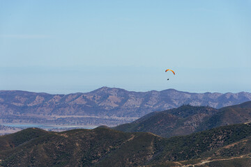 Paragliding Pilot Flying a Paraglider - 468452617