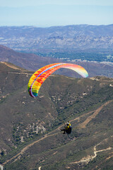 Paragliding Pilot Flying a Paraglider - 468452852