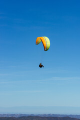 Paragliding Pilot Flying a Paraglider - 468452898