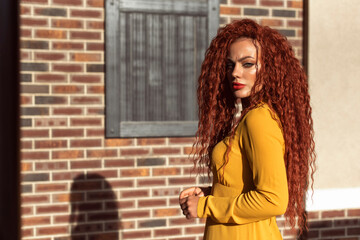 Fototapeta premium Redhead curly woman in the city