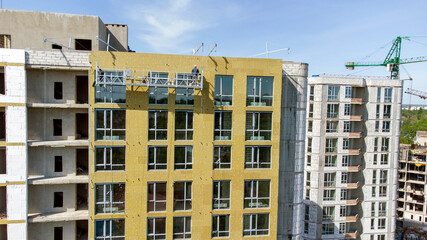 Building external wall thermal insulation with mineral wool. Exterior passive house wall heat insulation with mineral wool. Insulation the facade of commercial building. Energy efficiency