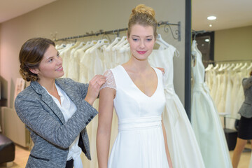 woman having bridal gown fitting in boutique