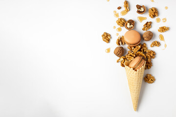 Macaroon cake with nuts in a waffle cone for ice cream on a white background