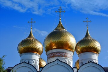 golden domes of the Assumption Cathedral in Yaroslavl, Russia against a blue sky