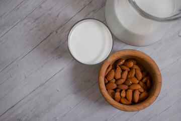 glass of milk, almonds on a wooden background