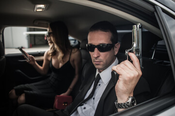 Agent bodyguard with gun protect celebrity VIP person in car