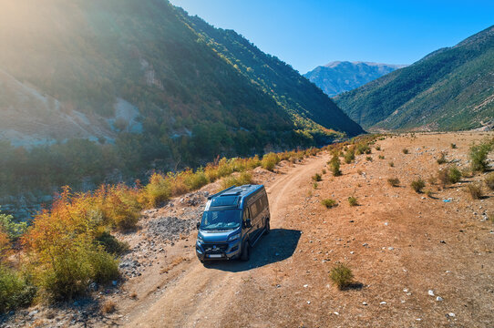 Off road campervan mobile home on  gravel road, against mountains and blue sky.  Albania .
