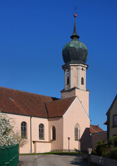 Fototapeta na wymiar Baroque village church of St Nikolaus with its onion dome tower and its gothic side chapel in Burgoberbach, Franken region in Germany
