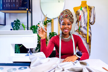 tanzanian woman with snake print turban over hear working in fashion house