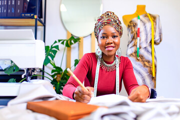 tanzanian woman with snake print turban over hear working in dressmaking shop