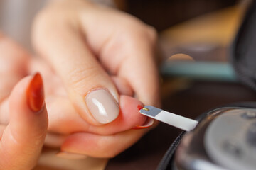 Woman testing for high blood sugar. Woman holding device for measuring blood sugar.