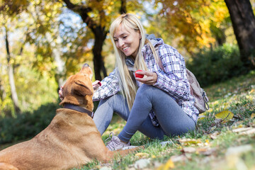 Fototapeta premium Positive young woman enjoying happy moments with her dog