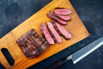 Traditional barbecue wagyu gourmet bavette steak served as top view on a modern design wooden board