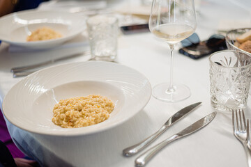 Italian rice risotto served hot in a deep plate in a restaurant.