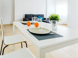 Simple white table in a very simple and bright minimalist living room.