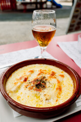 A plate of cannelloni with very cold beer.
