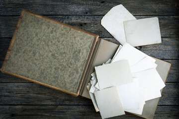 Family traditions, genealogy, the memories of ancestors and nostalgia concept. Clear blank photo frames to placed your pictures or text on old family album on wooden board background in retro style.