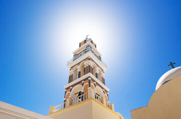 Fira town Church Clock Tower framed by the bright sunan. Santorini island Cyclades in Greece.