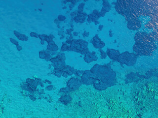 Fototapeta na wymiar Background image of the turquoise sea. Deep sea and corals. Aerial drone shot of turquoise water - space for text. Aquamarine background