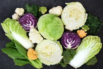 Fresh harvested vegetables from market on black background: white, red and savoy cabbage, broccoli and colorful cauliflower, napa cabbage and bok choy(pak choi) - obrazy, fototapety, plakaty